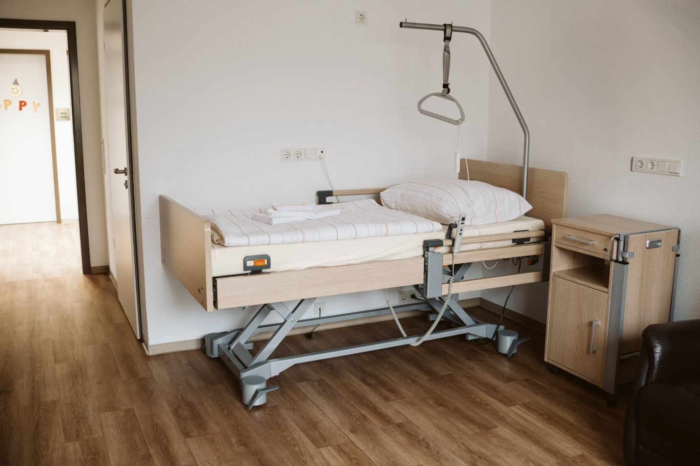 Ein verstellbares Krankenhausbett steht in einem modernen Zimmer.