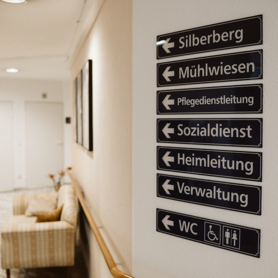 Beschilderung mit Richtungshinweisen zu verschiedenen Einrichtungen und Diensten.
