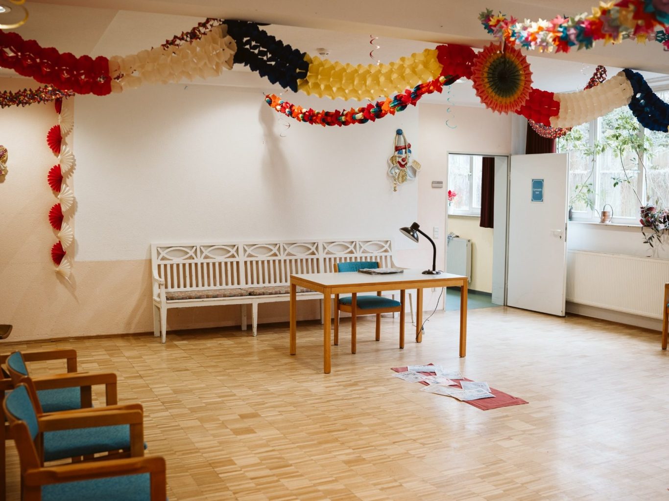 Ein festlich dekorierter Raum mit Tisch, Stühlen und bunten Luftballons.